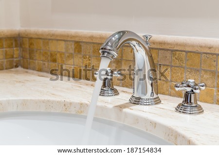 Modern water tap in the bathroom. Flowing water.
