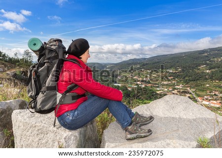 Woman traveler with a backpack resting. View of the beautiful landscape.
