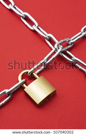 Padlock with chain on red background.