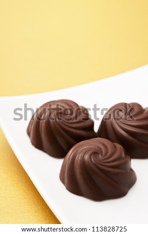 Chocolate and dish on gold background