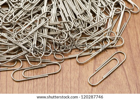 A lot of silver paper clip on wooden table