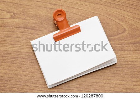 Memo pad and paper clip on wooden desk