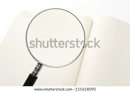 magnifying glass and open blank book, close-up