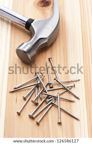 metal hammer and nail on wooden background