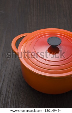A red enamel pot on a wooden table