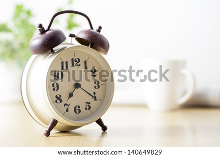 Traditional mechanical alarm clock on table