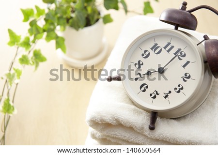 Traditional mechanical alarm clock on towel