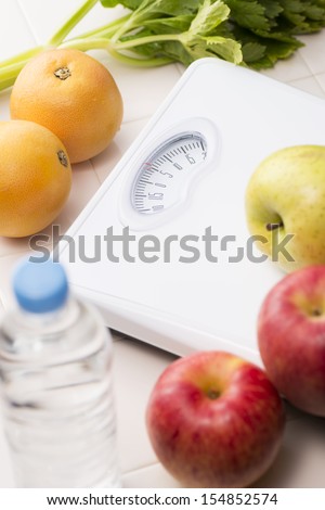 Scales and fruits and vegetables on tile floor
