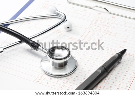 Medical record and Stethoscope, close up
