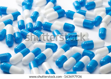 Blue and white capsules, medical background