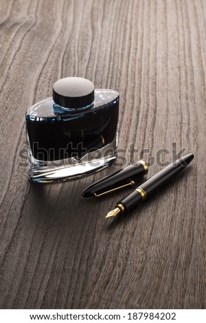 fountain pen and ink bottle on table