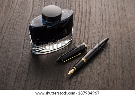fountain pen and ink bottle on table