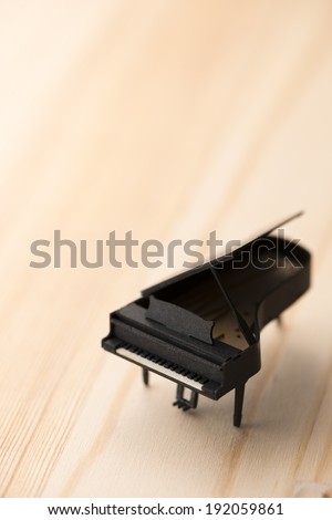 paper miniature piano on wooden background