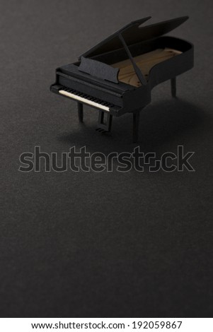paper miniature piano on black background