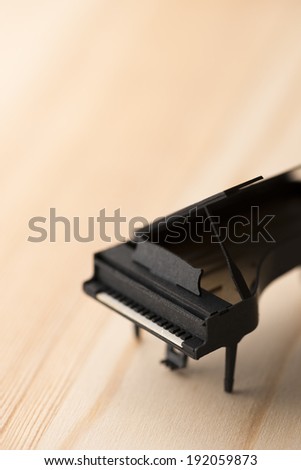 paper miniature piano on wooden background