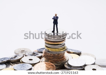 The doll business man on top of the stacked coins