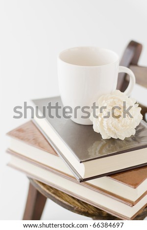 Wooden wall with old chair and books and cup