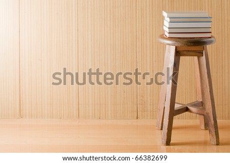 Wooden wall with old chair and books