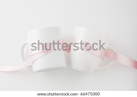 Pink ribbon wrapped around the cup isolated on white background