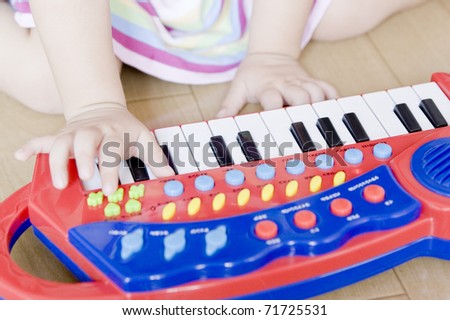 A little girl playing on a keyboard instrument.