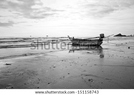 Old fishing boat landing on the beach. Black and white.