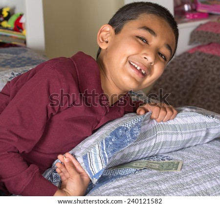 Happy Child Wakes Up To Find Money Under His Pillow Left by the Tooth Fairy