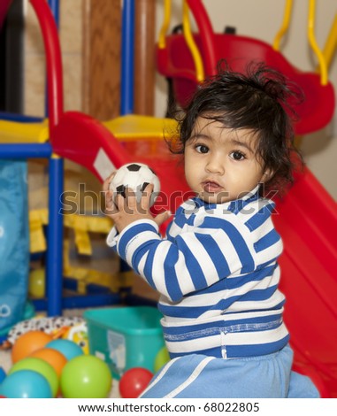 Baby Girl Playing with Balls in a Play Area