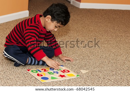 Preschooler Working On Numbers and Shapes Puzzle