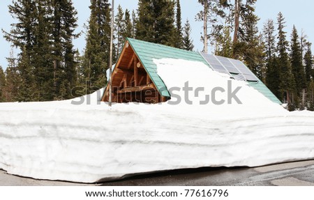 Snowed In Log Cabin with Solar Panels on Roof in Yellowstone National Park