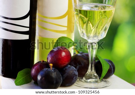Bottles of wine and plums on the table