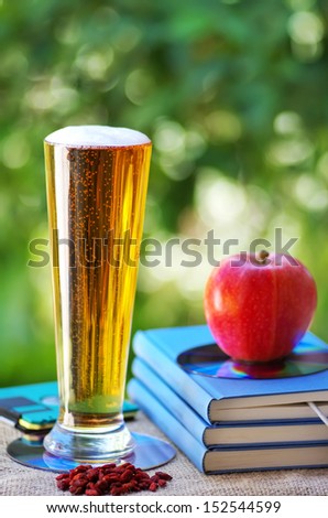 Cold beer and apple on books