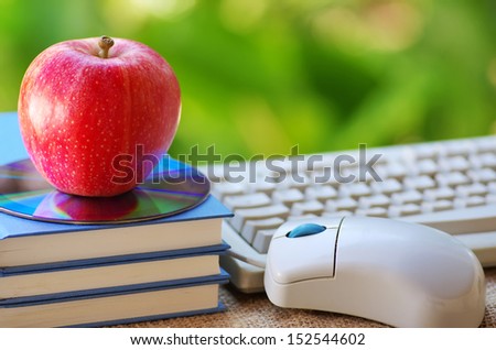Red apple on book, DVD and mouse