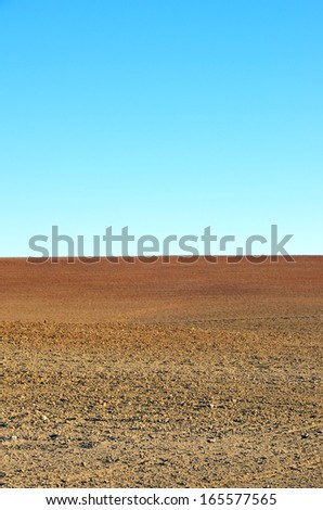 plowed soil of agricultural field against blue sky