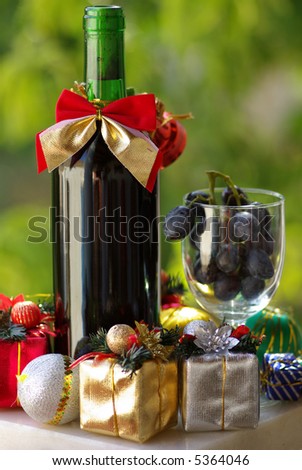 Decorated bottle of red wine with Christmas presents.
