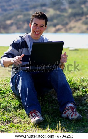 Young teen laptop man at countryside.