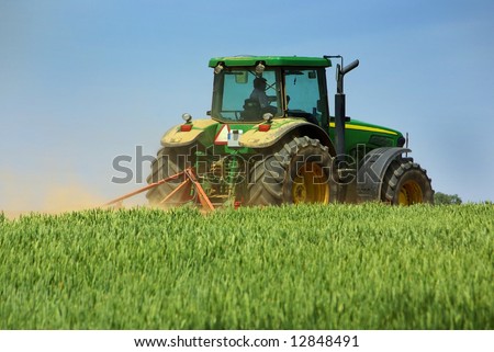 Green tractor working in the field.