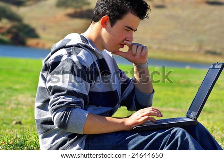 Young teen laptop man at countryside.