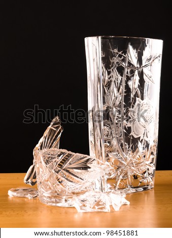 shards of broken vase lying next to another vase