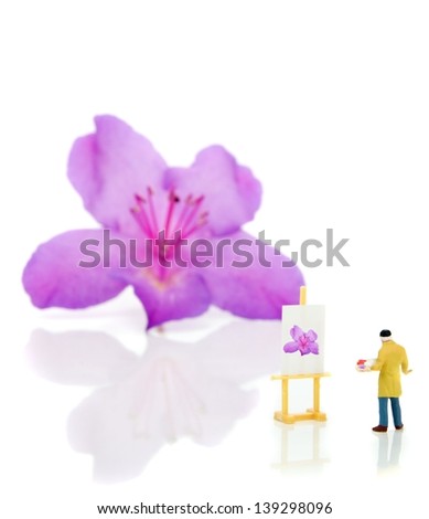 Miniature artist and easel painting a flower on white background