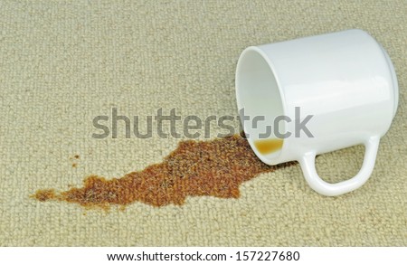 A spilled cup of coffee on a carpet with stain