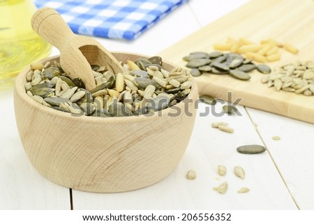 A mixture of seeds and pine nuts in a bowl on wooden table