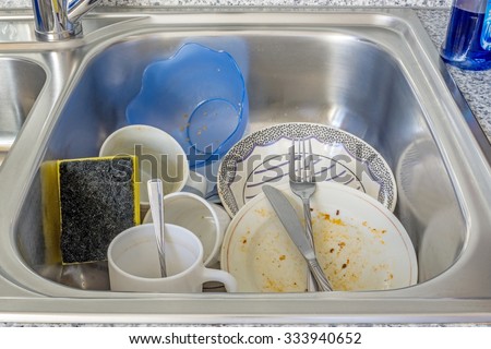 A small pile of dirty dishes in a kitchen sink