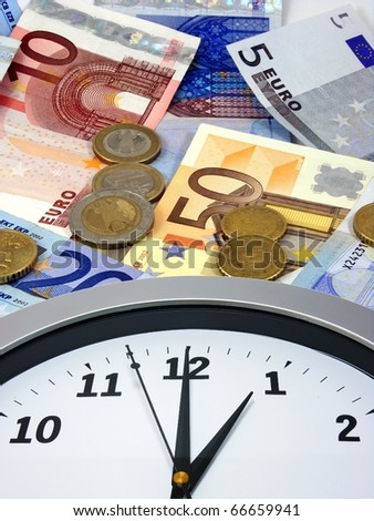 Time is money. A clock lying on a background of euro currency.