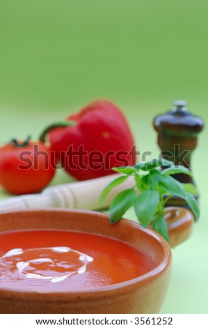 Fresh healthy tomato soup garnished with heart shaped cream drops and basil
