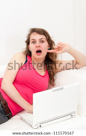 Portrait of a thinking woman looking up with laptop on couch