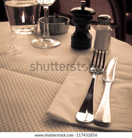 place setting - plate, knife and fork on table