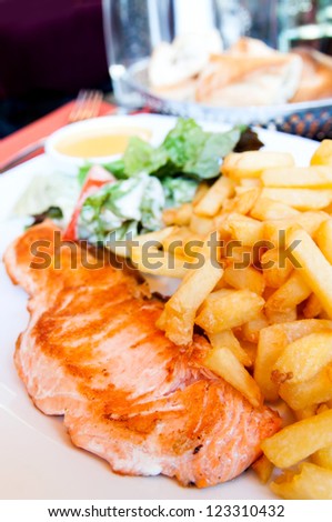 Delicious salmon-french dish on table