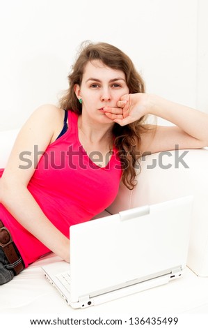 Thinking expression woman sitting comfortable with laptop on couch