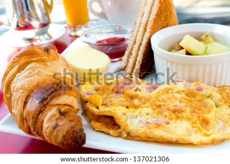 Breakfast with orange juice and omelet in a basket on table Breakfast with orange juice and omelet in a basket on table