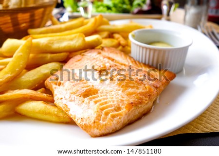 grilled salmon and fries - french cuisine dish with tomato and salmon